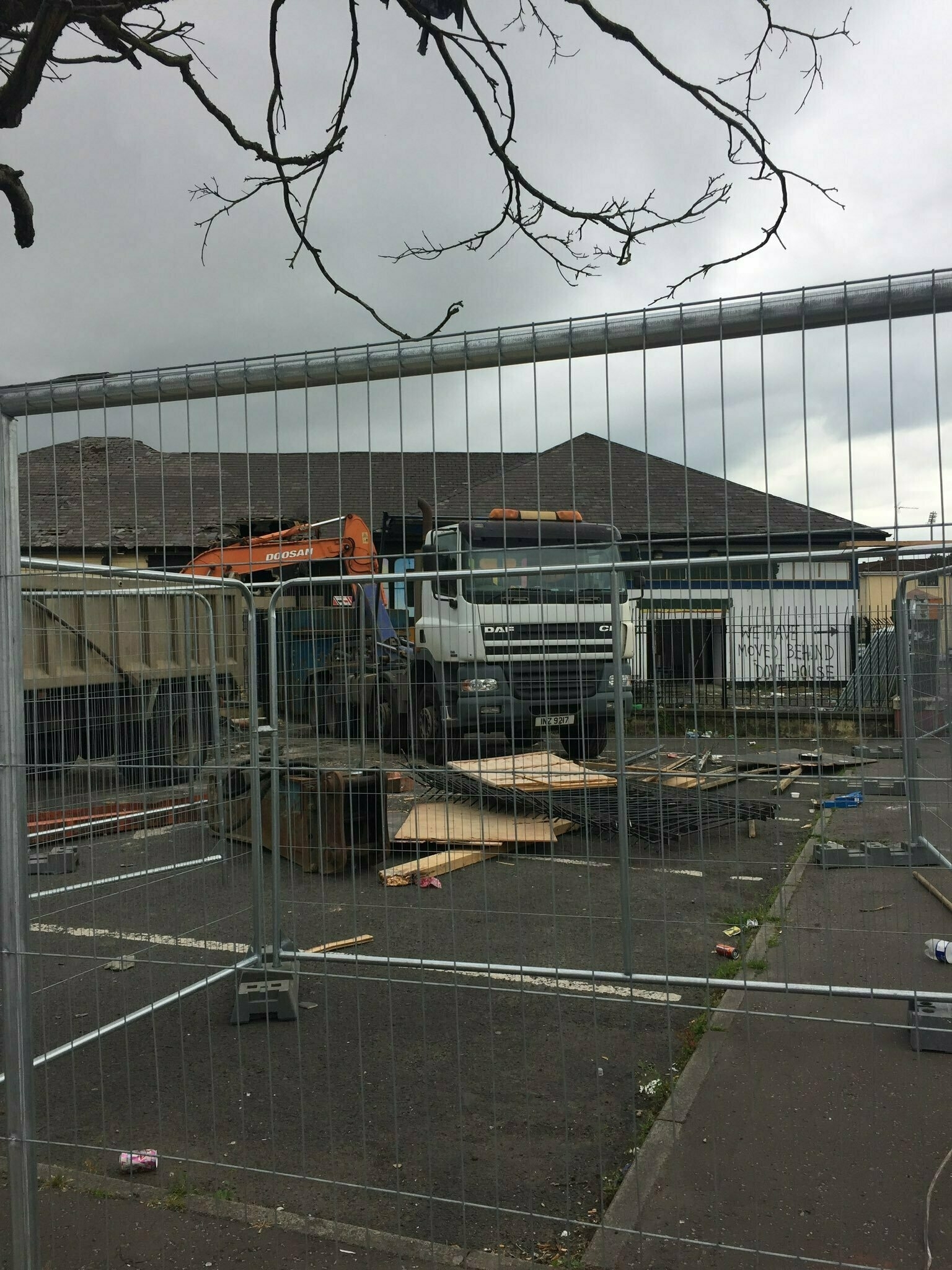 Demolition site surrounded by temporary fencing.